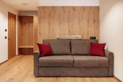 a living room with a couch with red pillows at Resciesa Hof in Ortisei