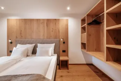 a bedroom with a large bed with wooden shelves at Resciesa Hof in Ortisei