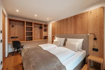 a bedroom with a large bed with wooden walls at Resciesa Hof in Ortisei