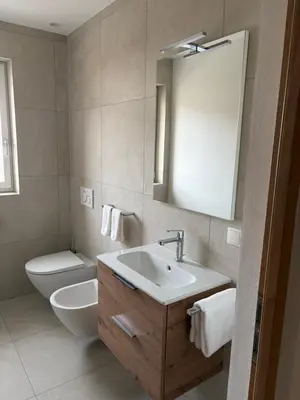 a bathroom with a sink and a toilet and a mirror at Residence Louise in Vipiteno