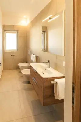 a bathroom with a sink and a toilet and a mirror at Residence Louise in Vipiteno