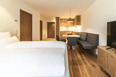a bedroom with a bed and a table and a couch at Residence Louise in Vipiteno