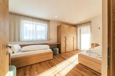 a bedroom with two beds and a window at Residence Louise in Vipiteno