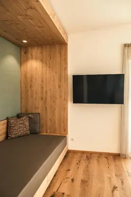 a room with a bed and a flat screen tv at Residence Louise in Vipiteno