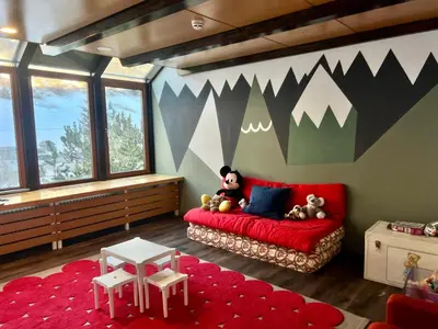 a room with a red couch with stuffed animals on it at Grifone Dolomiti Residences in Arabba