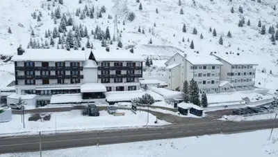 a hotel in the snow with snow covered buildings at Grifone Dolomiti Residences in Arabba