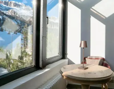 a room with a table in front of a large window at Grifone Dolomiti Residences in Arabba