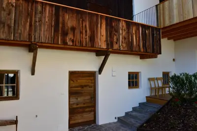 a stairway leading up to a house with a wooden deck at Apartments Mitterhof 1544 in Brunico