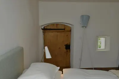 a room with two beds and a wooden door at Apartments Mitterhof 1544 in Brunico