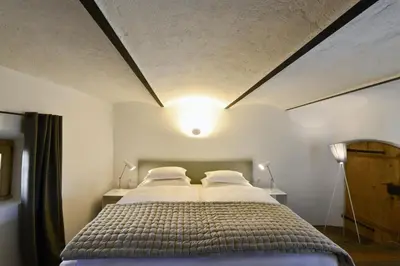 a bedroom with a large bed with two pillows at Apartments Mitterhof 1544 in Brunico