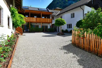 a driveway in front of a house with a fence at Apartments Mitterhof 1544 in Brunico