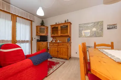 a living room with a red couch and a table at Appartamento Cordevole PT in Caprile