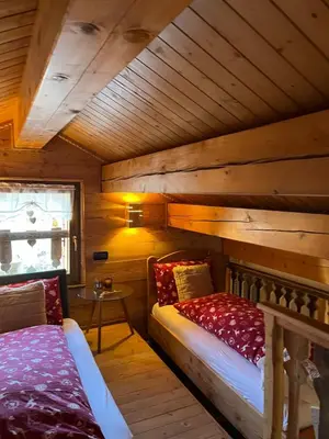 a room with two beds and a table in a cabin at Chalet Dolomiti - Camp - Alpine Eco stay in Vallalta