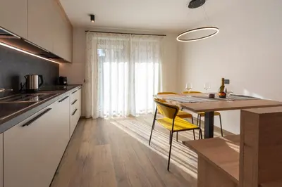 a kitchen with a table and a yellow chair at Vacanze la Malga in Predazzo