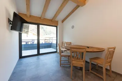 a dining room with a wooden table and chairs at Vacanze la Malga in Predazzo