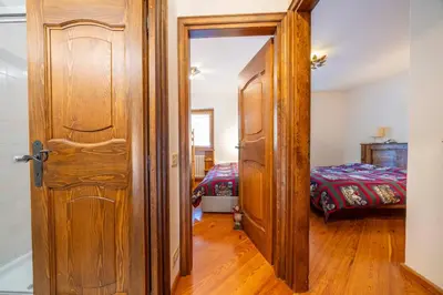 an open door to a bedroom with a bed at Le Gemelle Apartment in Cortina dʼAmpezzo