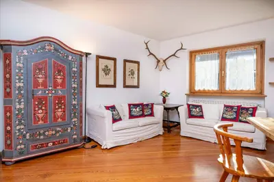 a living room with two white couches and a blue door at Le Gemelle Apartment in Cortina dʼAmpezzo