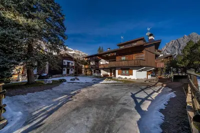 an empty road in front of a house at Le Gemelle Apartment in Cortina dʼAmpezzo