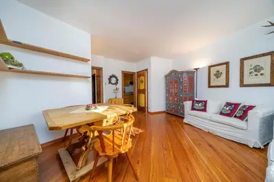 a living room with a table and a couch at Le Gemelle Apartment in Cortina dʼAmpezzo