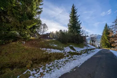 a snowy road with trees on the side of a hill at Le Gemelle Apartment in Cortina dʼAmpezzo