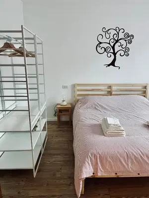 a bedroom with a bed and a tree on the wall at Al Monte Zelo in Agordo