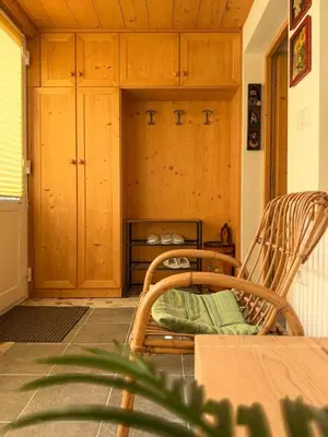 a room with a chair and a table and cabinets at Dolomiti Nest in Tesero