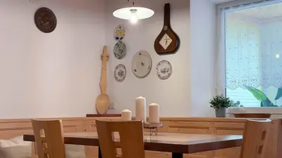 a dining room with a table and chairs and plates on the wall at Dolomiti Nest in Tesero