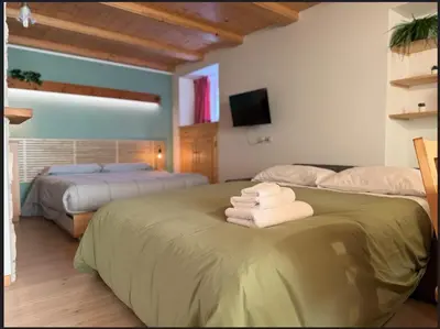 two beds in a room with towels on a bed at Dolomiti Nest in Tesero