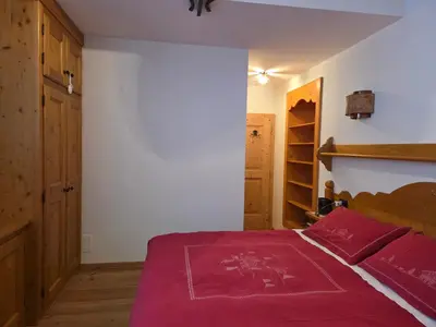 a bedroom with a bed with a red blanket on it at Meleres 11 in Cortina dʼAmpezzo