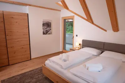 a bedroom with a large bed with white sheets at Modern apartment with mountain views in Chiusa