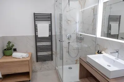 a bathroom with a shower and a sink and a tub at Modern apartment with mountain views in Chiusa