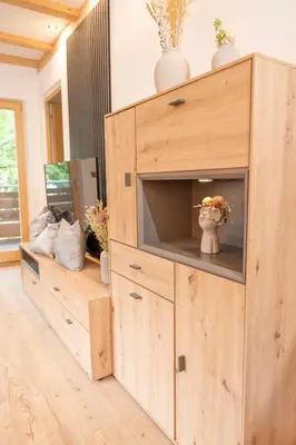 a wooden cabinet with a television in a room at Modern apartment with mountain views in Chiusa