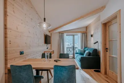 a kitchen and dining room with a wooden table and chairs at Garni Residence Alnö - Adults Only in San Vigilio Di Marebbe