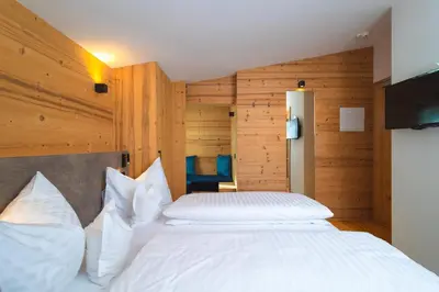 a bed with white pillows in a room with a window at Garni Residence Alnö - Adults Only in San Vigilio Di Marebbe