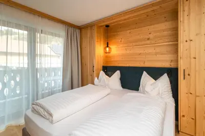 a bedroom with two beds and a window at Garni Residence Alnö - Adults Only in San Vigilio Di Marebbe