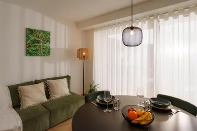 a living room with a table and a green couch at Mountain View Suites in Tesimo