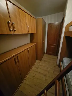 a small kitchen with wooden cabinets and wooden floors at Appartamento Federico in Rocca Pietore