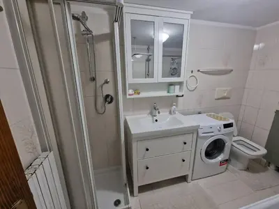 a bathroom with a sink and a washing machine at Appartamento Federico in Rocca Pietore
