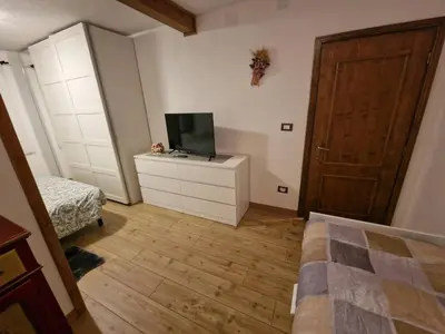 a bedroom with a bed and a television on a dresser at Appartamento Federico in Rocca Pietore