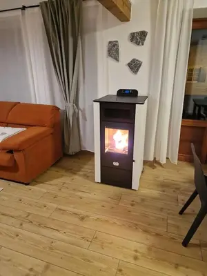 a living room with a stove in a room with a couch at Appartamento Federico in Rocca Pietore