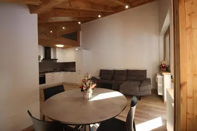 a kitchen and living room with a table and chairs at Penthouse with view 2 bedrooms free parking in Cortina dʼAmpezzo