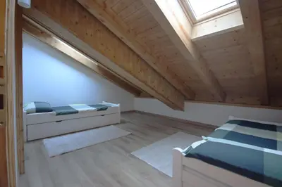 a attic bedroom with a bed and a skylight at Penthouse with view 2 bedrooms free parking in Cortina dʼAmpezzo