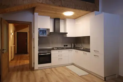 a kitchen with white cabinets and a stove at Penthouse with view 2 bedrooms free parking in Cortina dʼAmpezzo