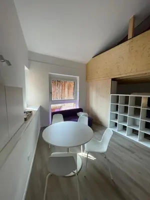a room with a table and chairs and a couch at Casetta in centro storico in Bedollo