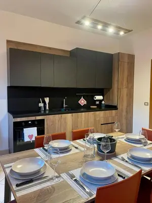 a dining room with a table with plates and wine glasses at Casa Marilu' in Taibon