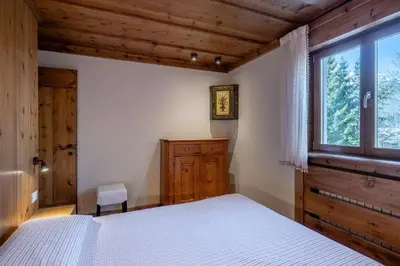 a bedroom with a bed and a window at Apartment Capriol by My Villa Collection in Cortina dʼAmpezzo