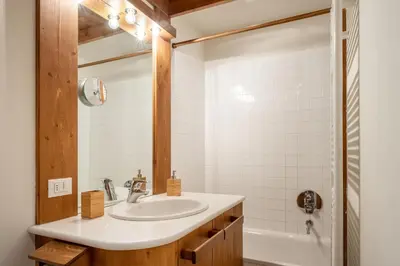 a bathroom with a sink and a tub at Apartment Capriol by My Villa Collection in Cortina dʼAmpezzo