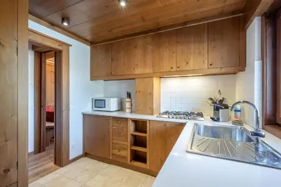 a kitchen with wooden cabinets and a sink at Apartment Capriol by My Villa Collection in Cortina dʼAmpezzo