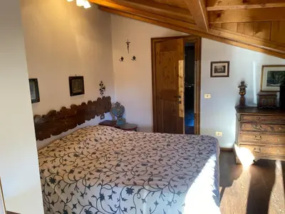 a bedroom with a large bed and a wooden dresser at 360-degree panoramic attic in Cortina in Cortina dʼAmpezzo