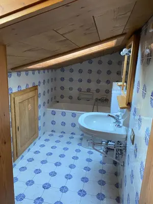 a bathroom with a sink and a blue tiled floor at 360-degree panoramic attic in Cortina in Cortina dʼAmpezzo